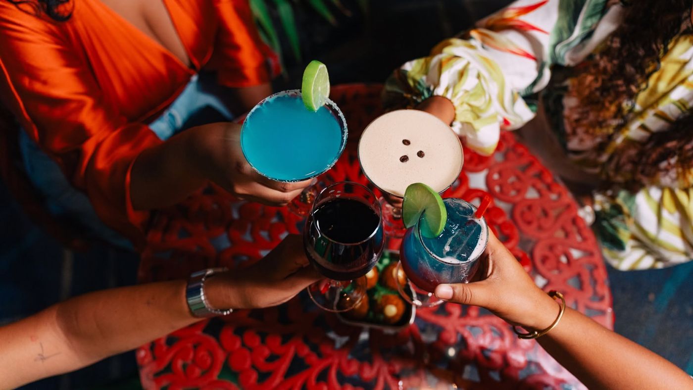 Friends toasting with colourful cocktails and wine